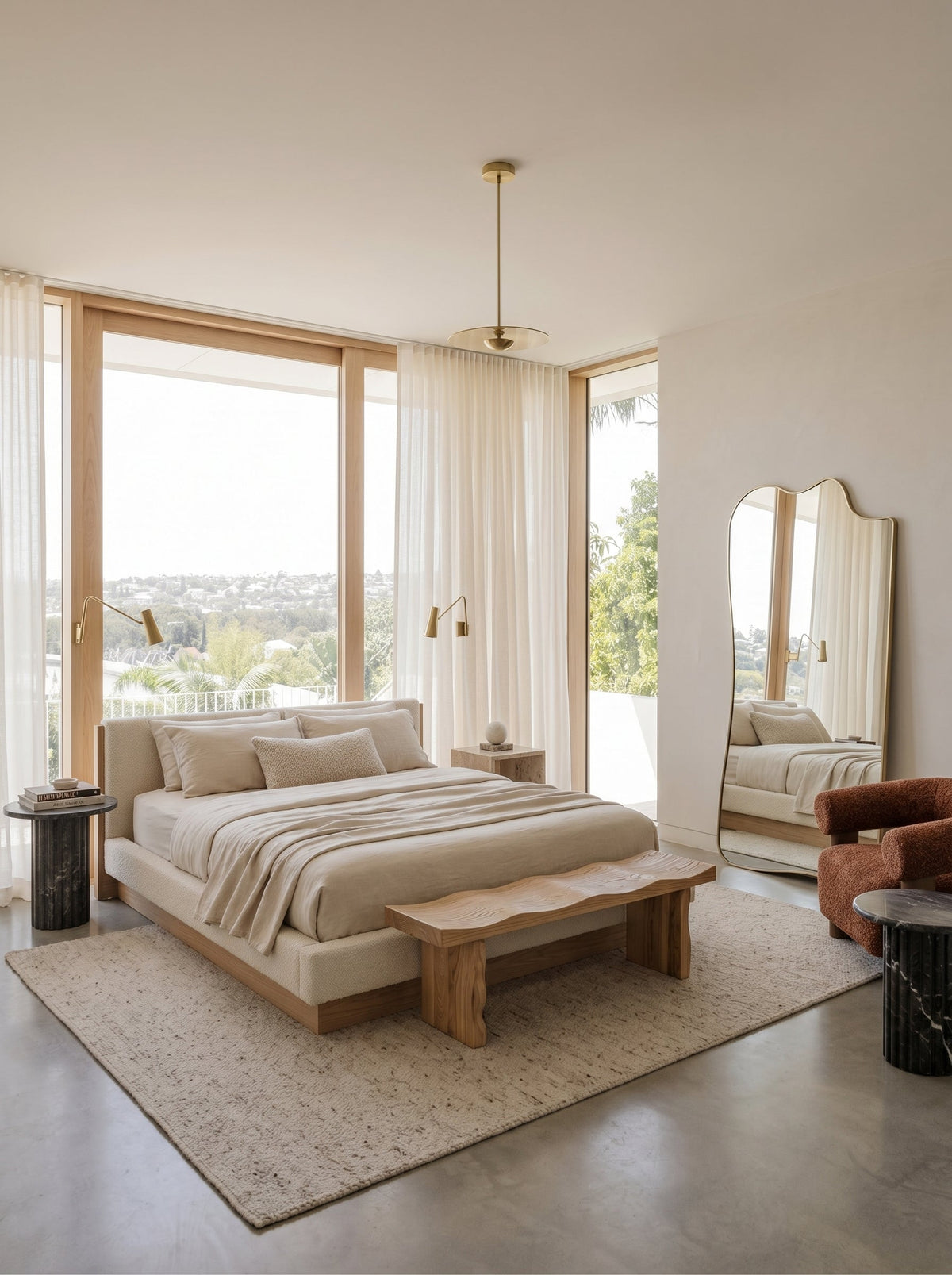 Champagne gold full-length asymmetrical mirror in a bright bedroom with large windows